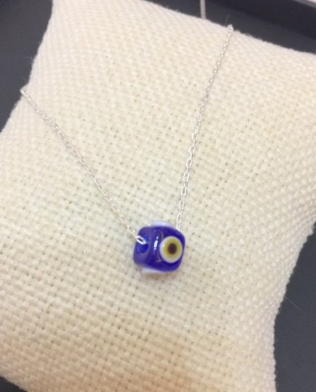 Handmade necklace featuring a blue evil eye bead on a sterling silver chain. Elegant and symbolic jewelry design.