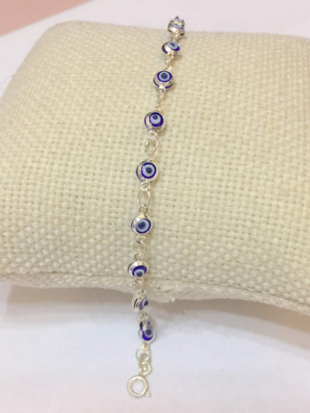 Sterling silver mini evil eye bracelet with purple bead charms and protective evil eye motifs for a chic and meaningful accessory.