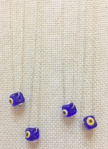 Handmade necklace featuring a blue evil eye bead on a sterling silver chain. Elegant and symbolic jewelry design.
