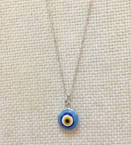 Turquoise evil eye necklace featuring a handmade glass bead pendant on a 925 sterling silver chain. Symbolic and elegant jewelry piece.