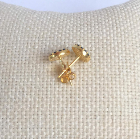 Gold-plated sterling silver evil eye stud earrings adorned with blue and white stones, a symbol of protection and style.