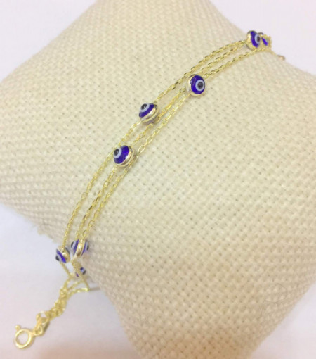 Gold-plated multi-layer bracelet with blue evil eye charms on delicate chains, combining elegance and symbolic protection.