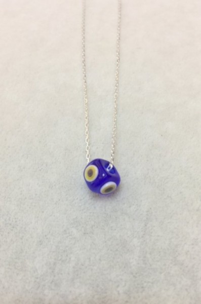 Handmade necklace featuring a blue evil eye bead on a sterling silver chain. Elegant and symbolic jewelry design.
