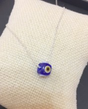Handmade necklace featuring a blue evil eye bead on a sterling silver chain. Elegant and symbolic jewelry design.