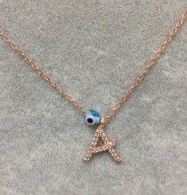 Close-up image of a personalized initial "A" necklace with cubic zirconia detailing and an evil eye charm, crafted in 18K gold-plated sterling silver.