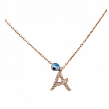 Close-up image of a personalized initial "A" necklace with cubic zirconia detailing and an evil eye charm, crafted in 18K gold-plated sterling silver.