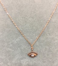Close-up image of a gold-plated sterling silver evil eye necklace with a cubic zirconia centerpiece, hanging on a delicate chain.