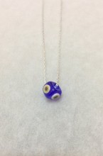 Handmade necklace featuring a blue evil eye bead on a sterling silver chain. Elegant and symbolic jewelry design.