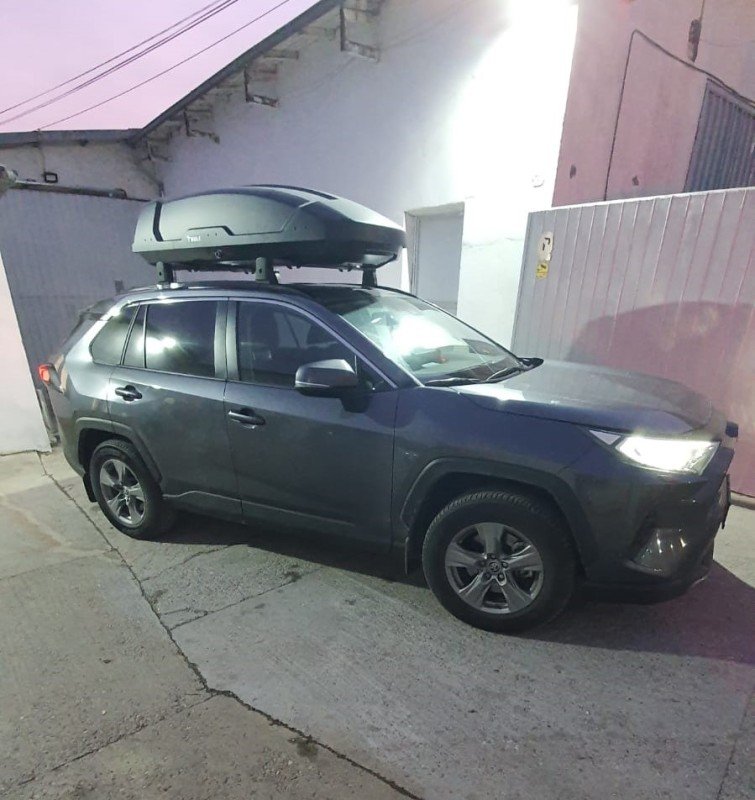 Toyota RAV4 with Menabo Dedicate OE roof bars and a black Thule Motion 3 L roof box