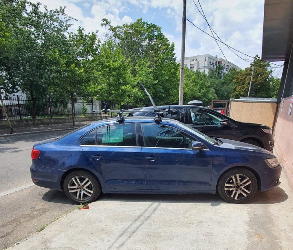 Volkswagen Jetta with Menabo Tema roof bars and a Thule FreeRide 532 bike rack