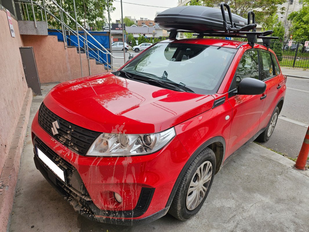 Suzuki Vitara with Menabo Delta roof bars, a Menabo Marathon roof box and a Menabo Niagara kayak & canoe rack