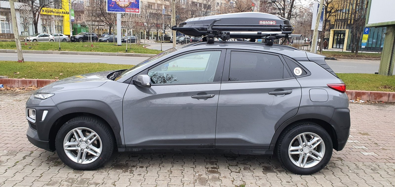 Hyundai Kona with Menabo Lince roof bars, a Menabo Diamond roof box and a Menabo Chrono bike rack