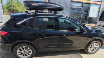 Ford Kuga with Menabo Sonic Black XL roof bars and a Menabo Marathon Dark 400 roof box