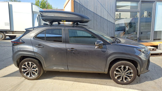 Toyota Yaris Cross with Menabo Ariem Black roof bars and a Menabo Marathon Dark 400 roof box