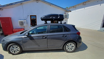 Hyundai i30 with Menabo Omega Plus Black roof bars and Thule Force 3 S roof box