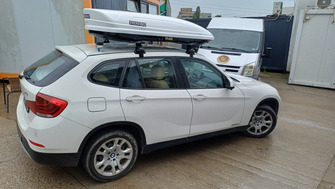 BMW X1 (E84) with Menabo Omega Plus Aluminium roof bars and a Menabo Mania 460 ABS White roof box