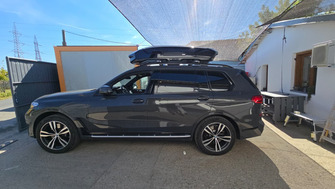 BMW X7 with Thule Evo Raised Edge Black roof bars and a Thule Motion 3 M roof box