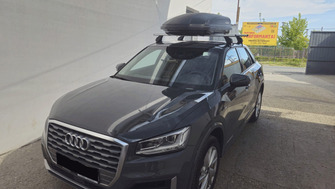 Audi Q2 with Menabo Omega aluminium roof bars and a Menabo Marathon Dark 400 roof box