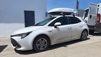 Toyota Corolla with Menabo Tema roof bars and a Menabo Mania 400 White roof box