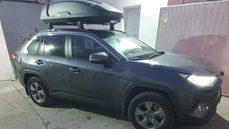 Toyota RAV4 with Menabo Dedicate OE roof bars and a black Thule Motion 3 L roof box