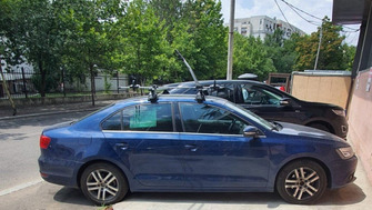 Volkswagen Jetta with Menabo Tema roof bars and a Thule FreeRide 532 bike rack