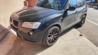 BMW X3 with Menabo Delta roof bars and a Thule SnowPack ski & snowboard rack