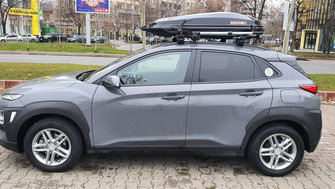 Hyundai Kona with Menabo Lince roof bars, a Menabo Diamond roof box and a Menabo Chrono bike rack