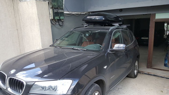 BMW X3 with Menabo Tiger Black roof bars and a Menabo Mania roof box