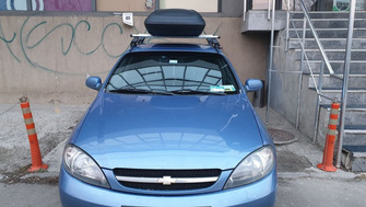 Chevrolet Lacetti with Menabo Tema roof bars and a Carbon Look roof box