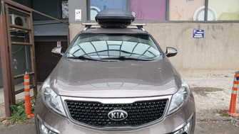 Kia Sportage with Menabo Lince roof bars and a Menabo Marathon roof box