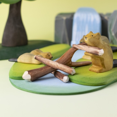 Black poplar twigs arranged in a beaver dam play scene with water and animals.
