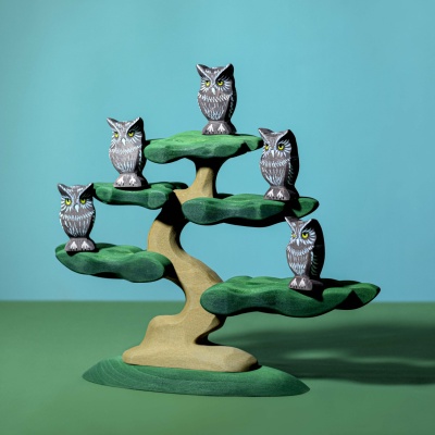 Image of the owl toy incorporated into a child's imaginative nature scene, with other toys or natural materials.