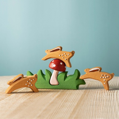 The toy incorporated into a fairy garden scene with miniature houses and plants.
