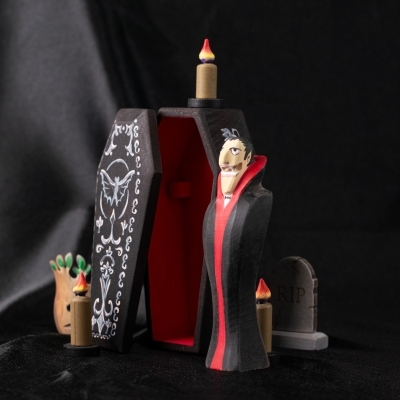 Dracula vampire figure emerging from a wooden coffin in Halloween-themed setup