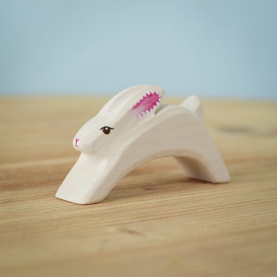 Handcrafted wooden Easter Rabbit Running on a wooden surface.