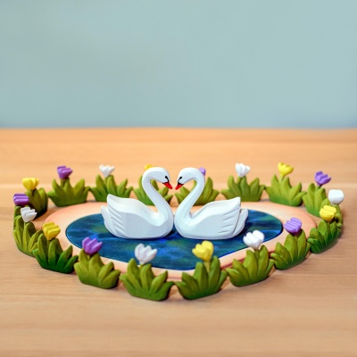 Elegant swans gracing a heart lake, a serene scene from Bumbu Toys.