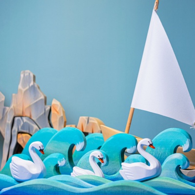 Hand-painted swans on a wooden lake, Bumbu Toys' ode to peaceful togetherness.