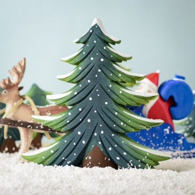 Snowy Fir Tree featured in a winter scene with reindeer and Santa.