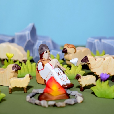 A child using the sheep figurine to create a story alongside other animal figurines.