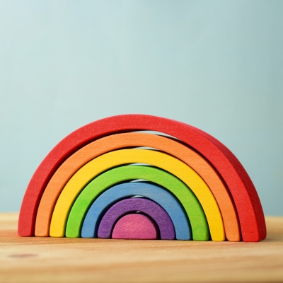 Handmade Small Rainbow wooden toy on a wooden surface.