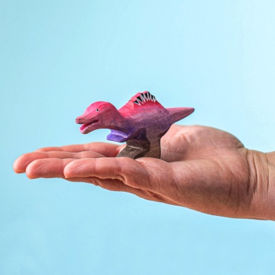 Wooden Spinosaurus Baby toy held in hand for size reference
