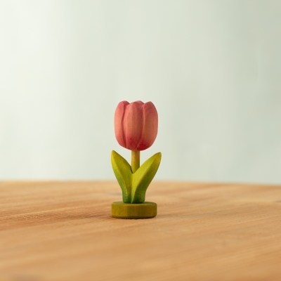 Row of colorful wooden spring flowers standing on individual green wooden bases