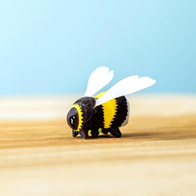 Side view of a wooden bumblebee figurine with detailed painting