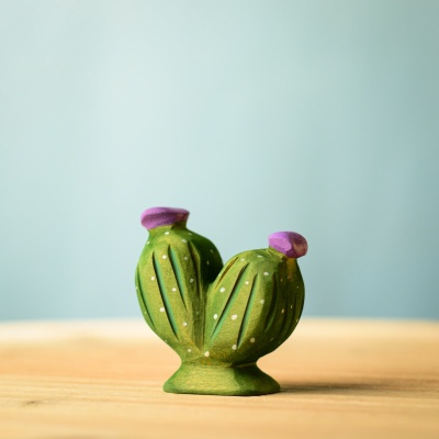 Handcrafted wooden pin cushion cactus on a wooden surface