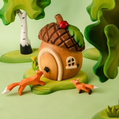Front view of the wooden acorn house with a pink wooden fairy and white bunny nearby