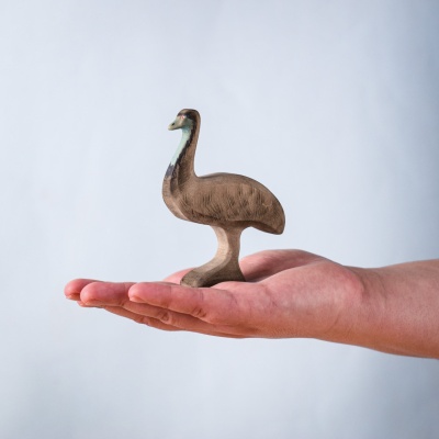 Wooden emu toy resting in an open palm to show scale