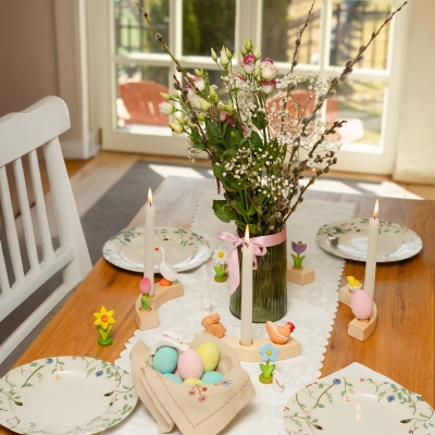 Easter table setting with candles in a wooden ring decorated with a forget-me-not