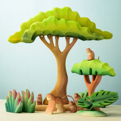 Group of Monkey wooden toys in a vibrant play scene with trees.