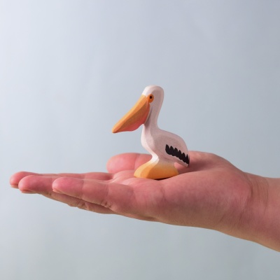Wooden Pelican toy resting gently in a child’s palm