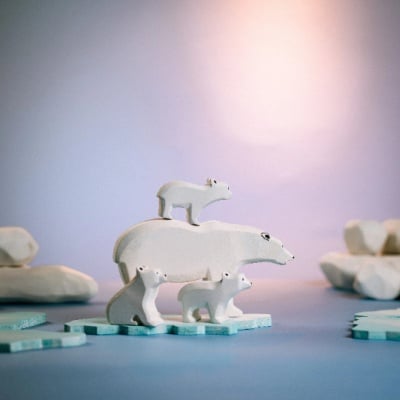A mother polar bear and cubs on an ice floe, a wooden set crafted with care by BumbuToys.